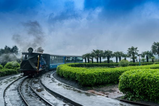 May 01,2017.The Darjeeling Himalayan Railway, also known as the Toy Train, is a 2 ft narrow gauge railway,is entering to the Batasia loop,Darjeeling, west bengal, India. after a heavy rainfall.